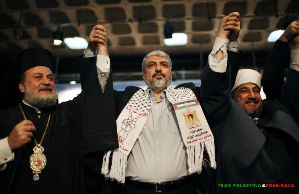 Hamas chief Khaled Meshaal raises hands with Greek Orthodox Archbishop Alexios (L) and senior Muslim cleric Hassan Al-Jojo (R) during a ceremony in Gaza City December 9 2012