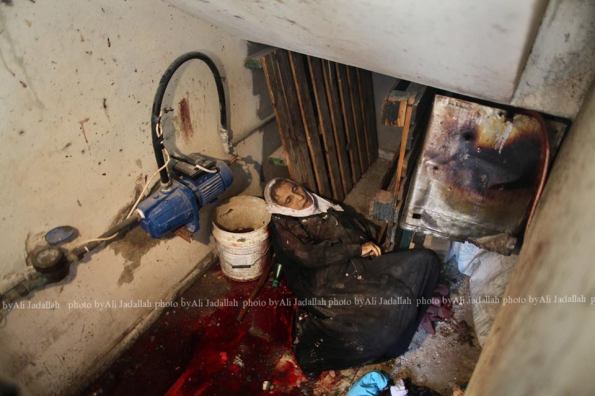The body of a elderly woman, who medics said was killed during heavy Israeli shelling, is seen at her house in the Shejaia neighborhood, which was heavily shelled by Israel during fighting, in Gaza City July 20, 2014. At least 50 Palestinians were killed on Sunday by Israeli shelling in a Gaza neighborhood, where bodies were strewn in the street and thousands fled for shelter to a hospital packed with wounded, witnesses and health officials said. Militants kept up their rocket fire on Israel, with no sign of a diplomatic breakthrough toward a ceasefire in sight. REUTERS/Ali Hassan 